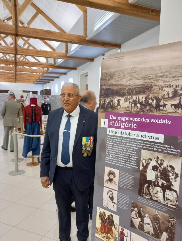 Le président de l'association "Harkis 49" devant une affiche de l'exposition de l'ONACVG